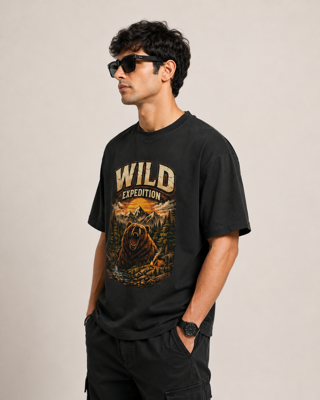 Man wearing a black t-shirt with 'Wild Expedition' graphic design on a beige background