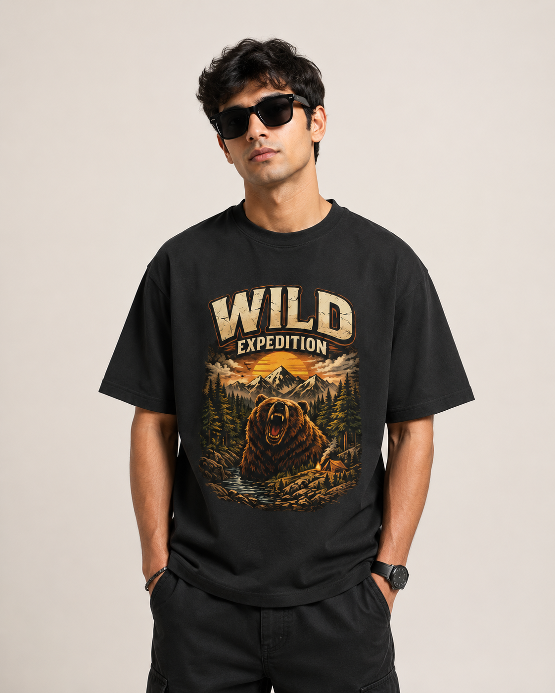 Man wearing a black t-shirt with 'Wild Expedition' graphic design on a beige background