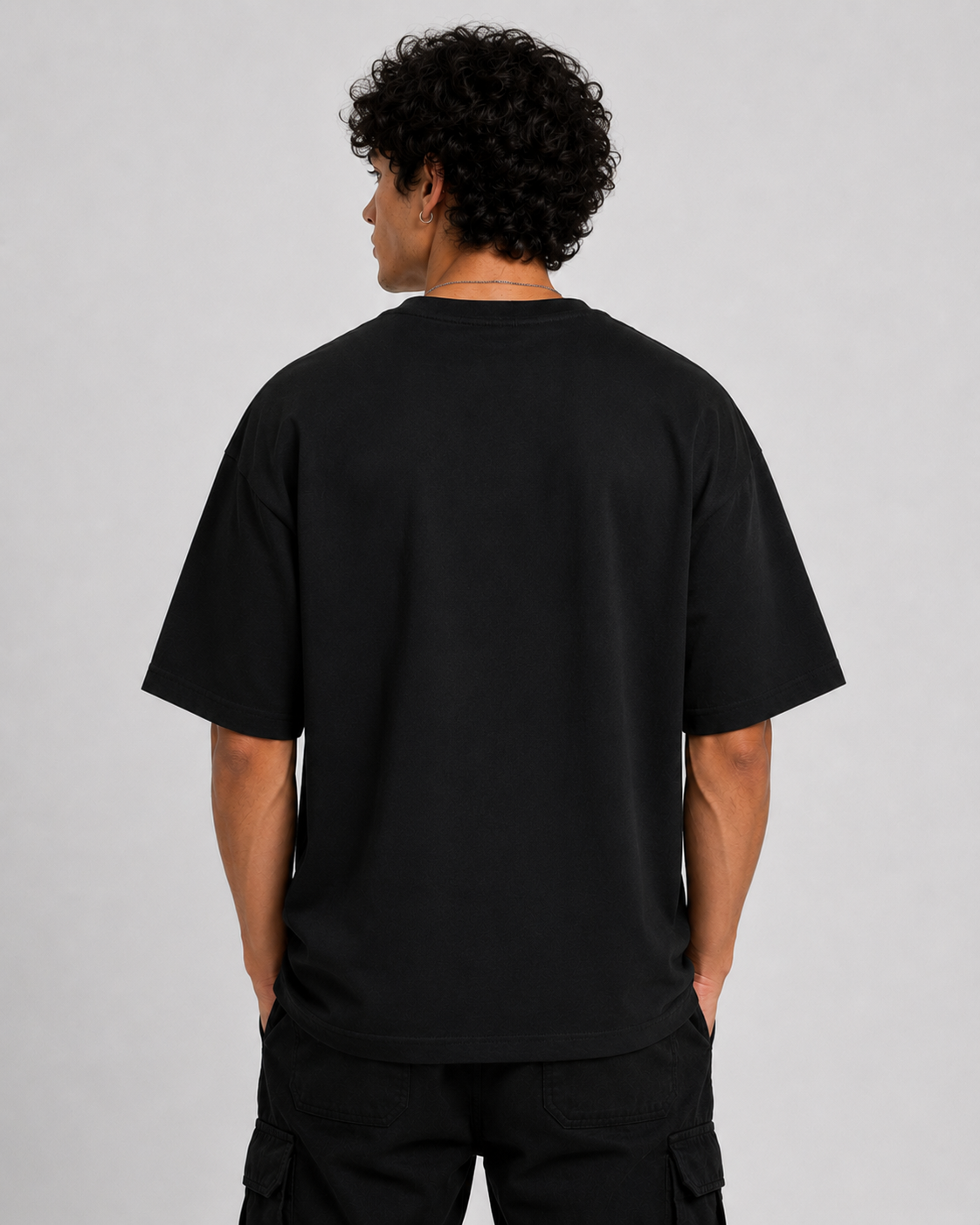 Person wearing a black t-shirt on a plain background