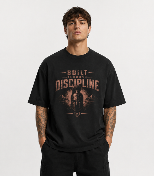 Man wearing a black t-shirt with 'Built Through Discipline' text and graphic on a white background