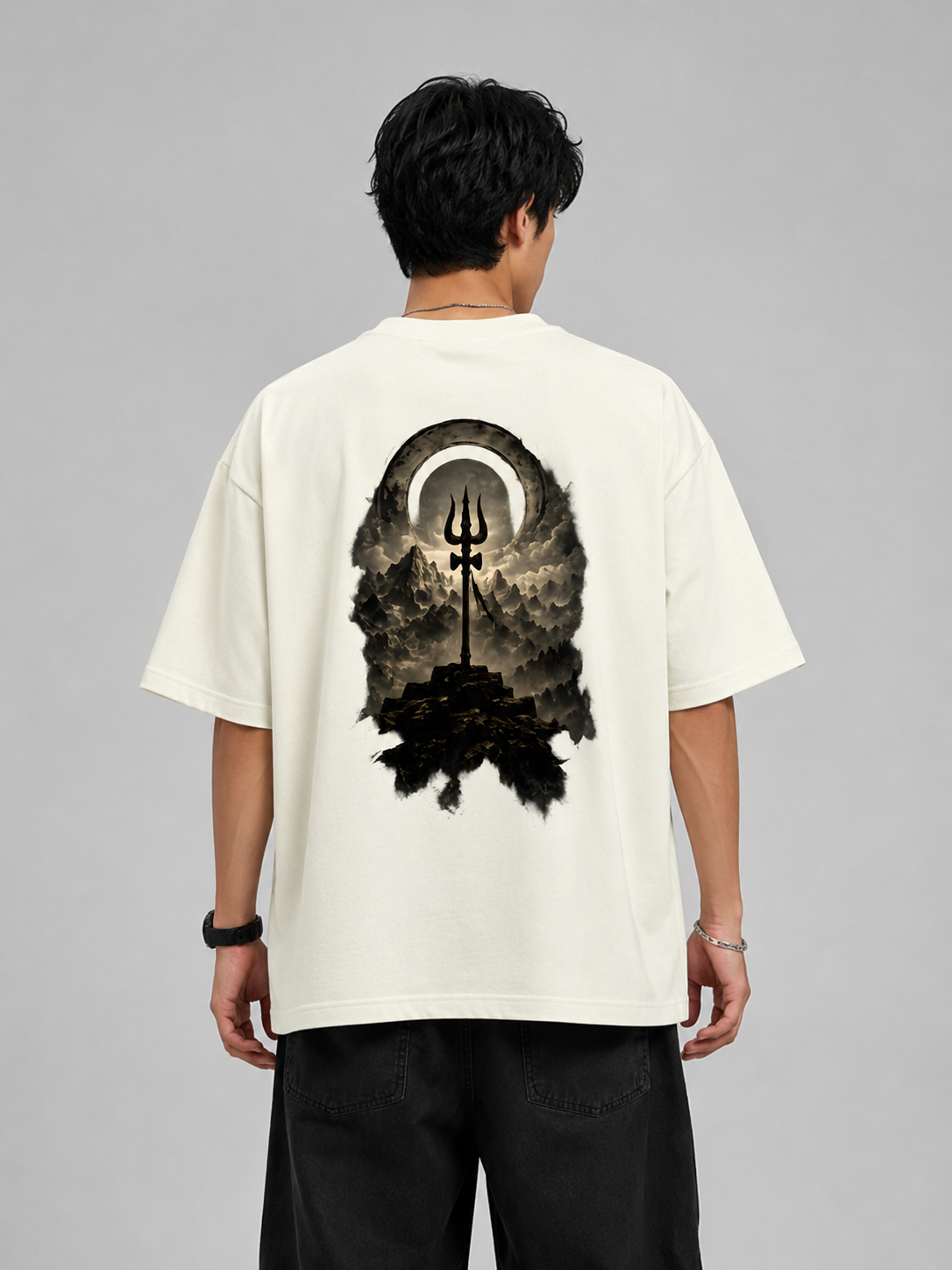 Person wearing a white t-shirt with a black graphic design on the back against a gray background