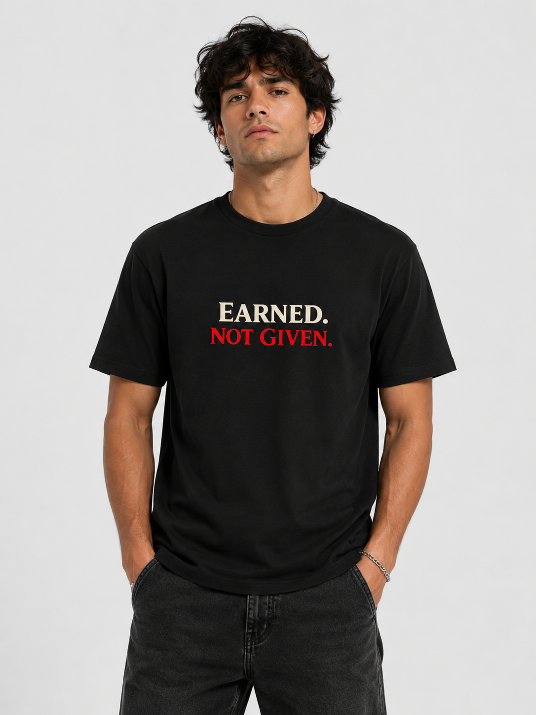 Man wearing a black t-shirt with 'Earned, Not Given' text on a plain background