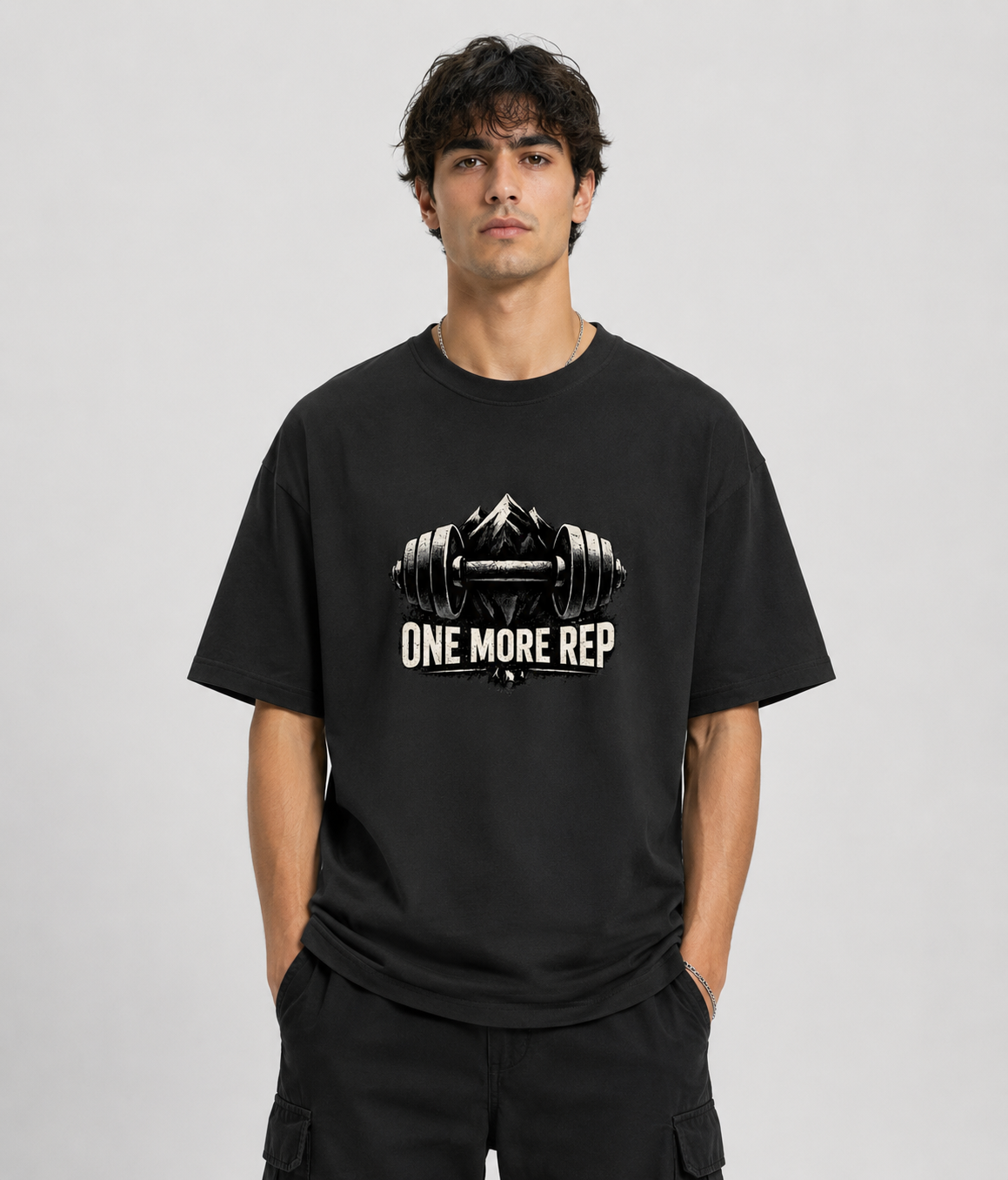 Person wearing a black t-shirt with 'One More Rep' graphic design on a plain background