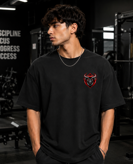 Person wearing a black t-shirt with a red and white logo in a gym setting