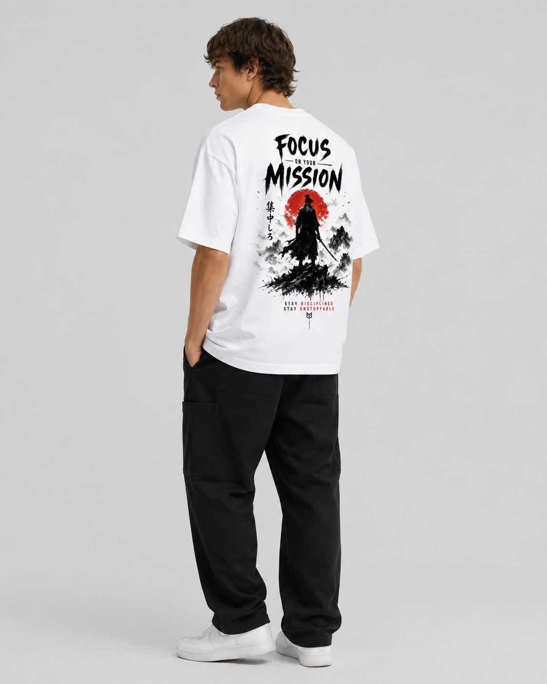 Person wearing a white t-shirt with a graphic design and text on the back, standing against a plain background.