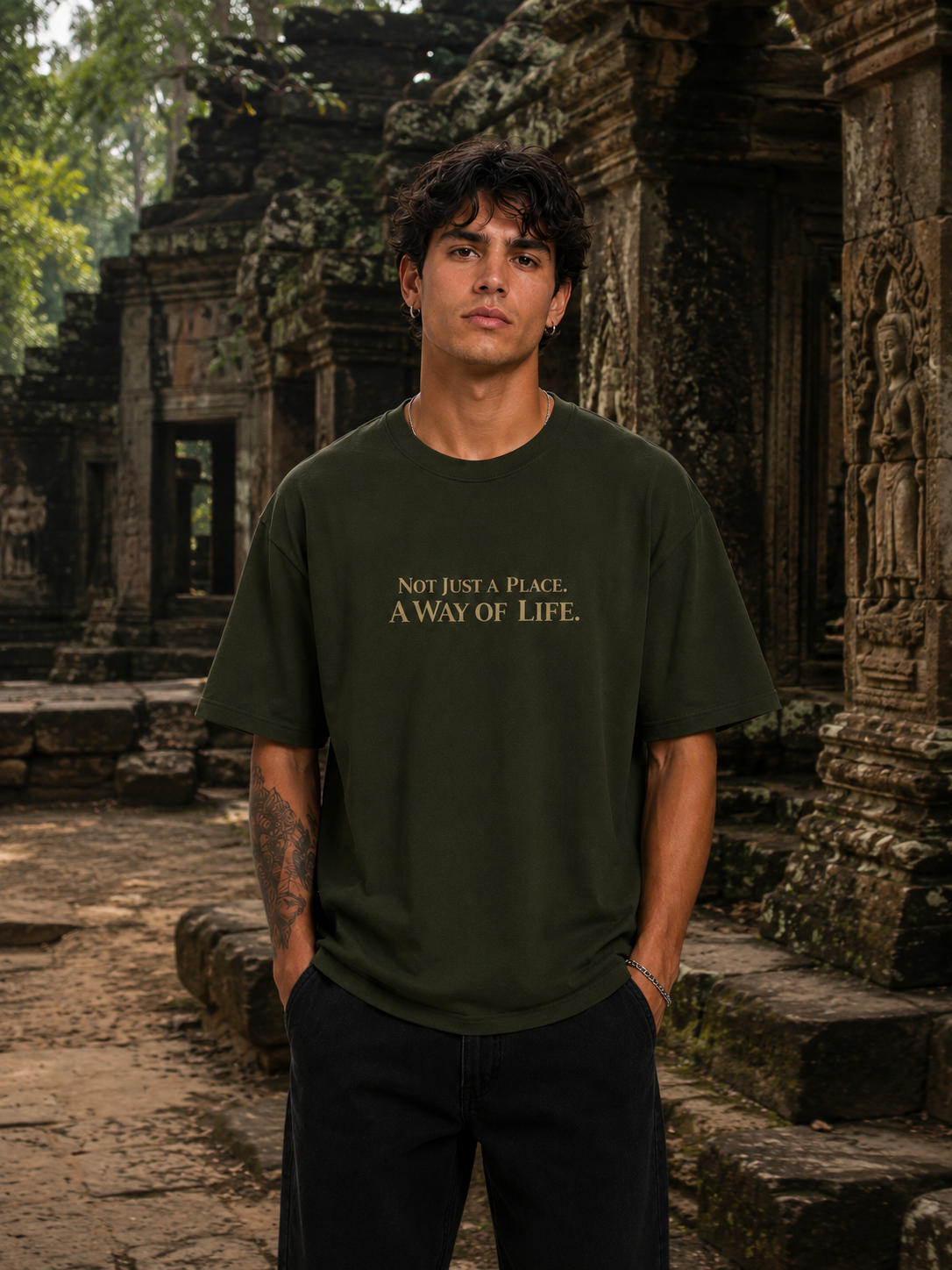 Person wearing a green t-shirt with text in front of ancient ruins