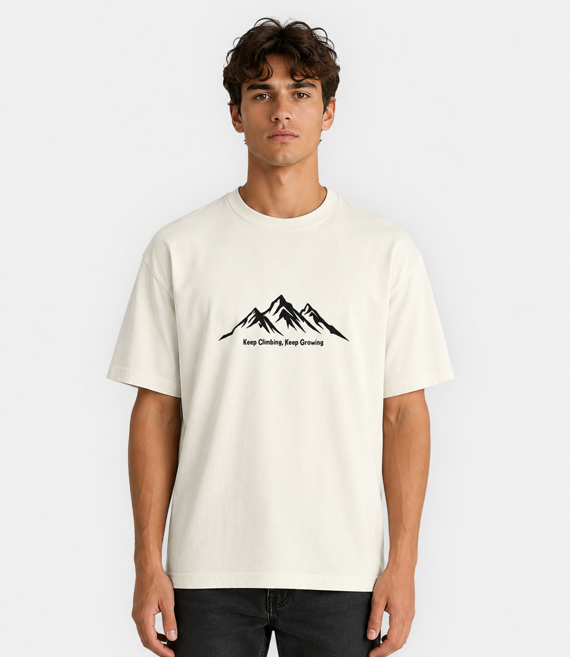 Man wearing a white t-shirt with a mountain graphic and text on a plain background